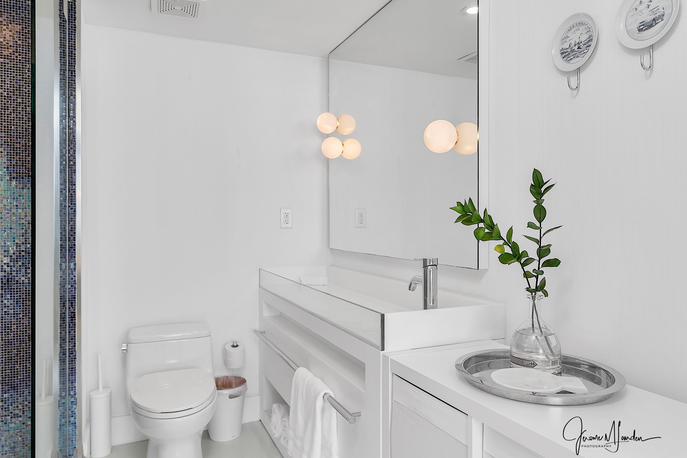 Main bathroom with globe lights and blue mosaic tiles